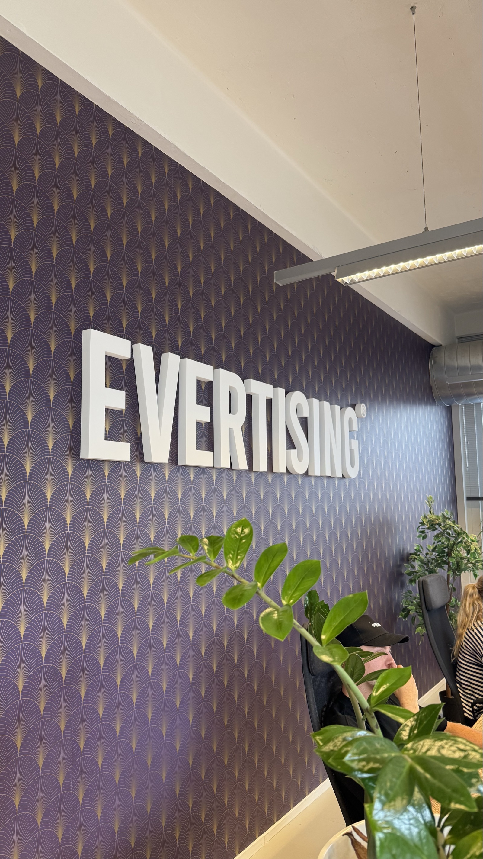 Het Evertising-logo aan de muur van het kantoor in Den Haag